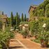 Agriturismo La Sovana in Sarteano with ivy-covered walls and a brick courtyard garden lined with cypress trees