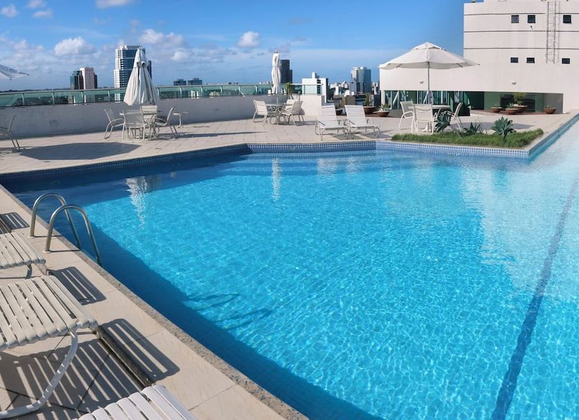 Rooftop pool at Iguatemi Business & Flat by Avectur in Salvador with city views and lounge chairs