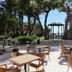 Hotel Son Caliu Spa Oasis in Palma Nova: outdoor terrace with tables, chairs, trees and sea view