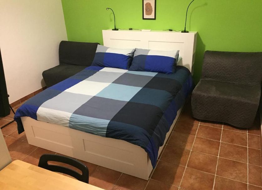 Celtic House B&B in Varazze bedroom with double bed, two sofas, and green accent wall