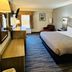 Quality Inn Danville - University Area guest room with king bed, desk, window and sitting chair in Danville