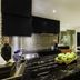 Downtown Villas Kuta kitchen with black marble island, apples, and mirrored backsplash