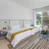 Al Zorah Beach Resort in Ajman: bright guest room with twin beds, sofa, and large floor-to-ceiling windows