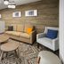 Candlewood Suites Williamsport guest lounge with sofa, chairs, coffee tables and desk area