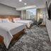 Hilton Garden Inn Mexico City Polanco guest room with two beds, city view, and modern chair