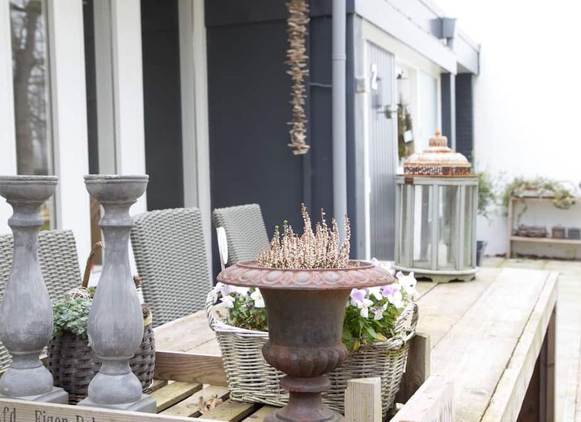 Bed & Breakfast Rijsterbosch in Rijs: patio with wicker chairs, planter, and decorative urns