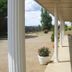 Garden Motor Inn, Gundagai: covered exterior walkway with columns, potted flowers and open garden views