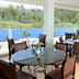 Blooming Paradise Thekkady dining room with round tables and large windows overlooking greenery and a blue pool