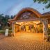 Vijayshree Resort, Hampi in Hosapete: illuminated resort entrance with cobblestone driveway and parked car