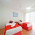Beach Court Holiday Villas in Airlie Beach twin bedroom with red bedding and vertical blinds