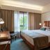 Hotel Dom Goncalo & Spa in Fátima guest room with king bed, desk, chair and window with palm view