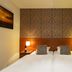 B&B Brasserie Lakerhof in Ohe en Laak bedroom with twin beds, bedside lamps and patterned headboard