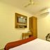 Hotel Golden Inn Chandigarh guest room with bed, wall-mounted TV, wardrobe and chair