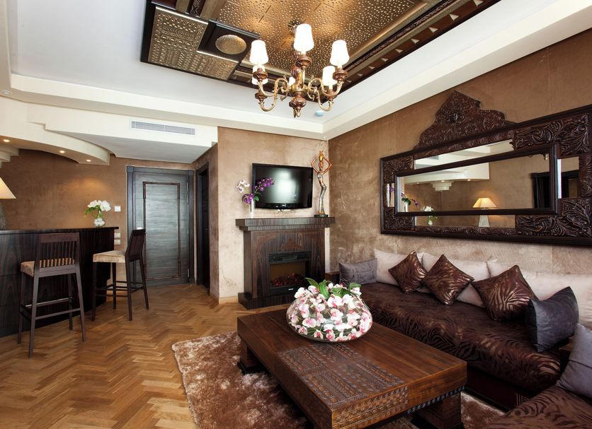 Art Palace Suites & Spa in Casablanca: elegant suite with seating area, chandelier, bar nook, and TV