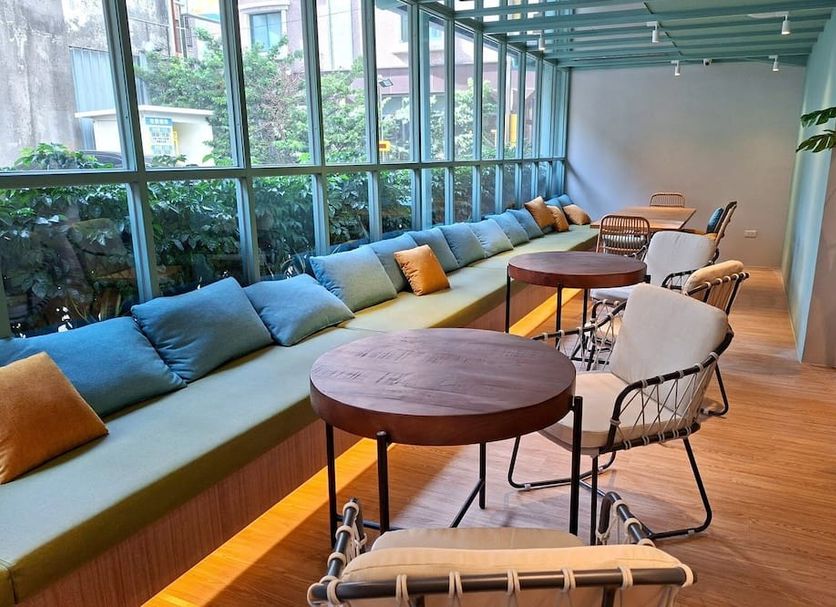 Via Hotel Zhongli lounge seating area with large windows and wooden tables in Taoyuan City