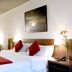 Dazzler by Wyndham Buenos Aires Maipu guest room with king bed, red accents, desk and wall art in Buenos Aires