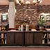 The Hoxton Portland in Portland lobby with brick wall, bookshelf front desk, and lounge seating