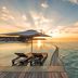 Hurawalhi Island Resort in Komandoo: oceanfront infinity pool at sunset with loungers and sea view