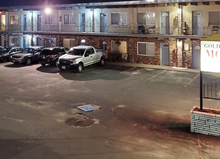 Golden Gate Lodging in Plattsburgh exterior with parked cars in a motel-style lot at night