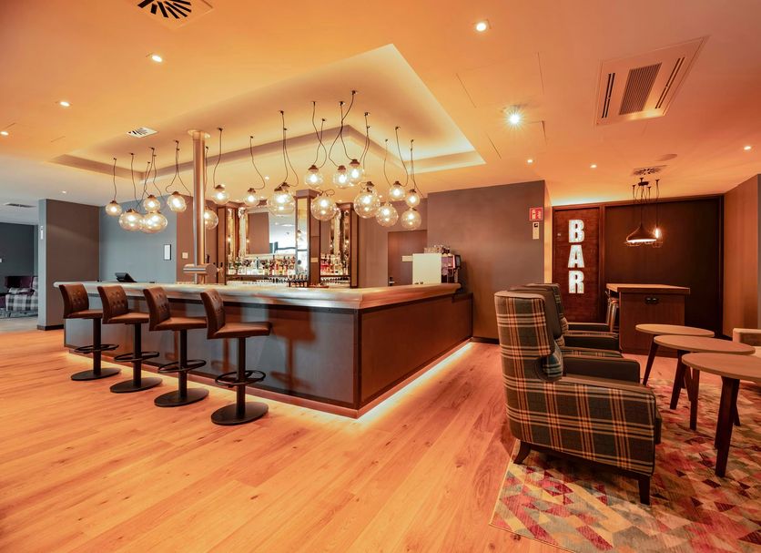 Premier Inn Karlsruhe City Am Wasserturm bar lounge with stools, armchairs and warm ambient lighting