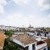Patios del Orfebre in Córdoba with rooftop city views over whitewashed buildings and church spire