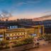 James Joyce Coffetel Hotel in Qinhuangdao at dusk with illuminated exterior and city skyline