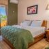 Hotel Manuel Antonio room with king bed, balcony doors, and tropical ocean-view greenery in Manuel Antonio