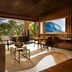 Four Seasons Resort Lanai in Lanai City lounge with ocean view, open doors, and tropical greenery