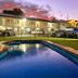 Countryman Motor Inn in Dubbo with a lit outdoor pool and motel rooms at dusk