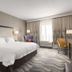 Hampton Inn Turlock guest room with king bed, desk, chair, and window with curtains