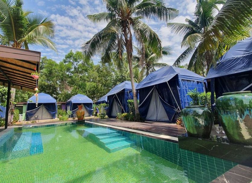 Moonshine Resort Chumphon poolside glamping tents and palm trees in Chumphon