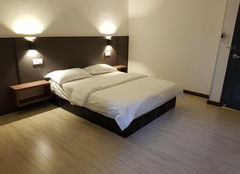 Luna Capsule in Semporna, simple hotel room with double bed, wall lights and light wood flooring