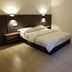 Luna Capsule in Semporna, simple hotel room with double bed, wall lights and light wood flooring