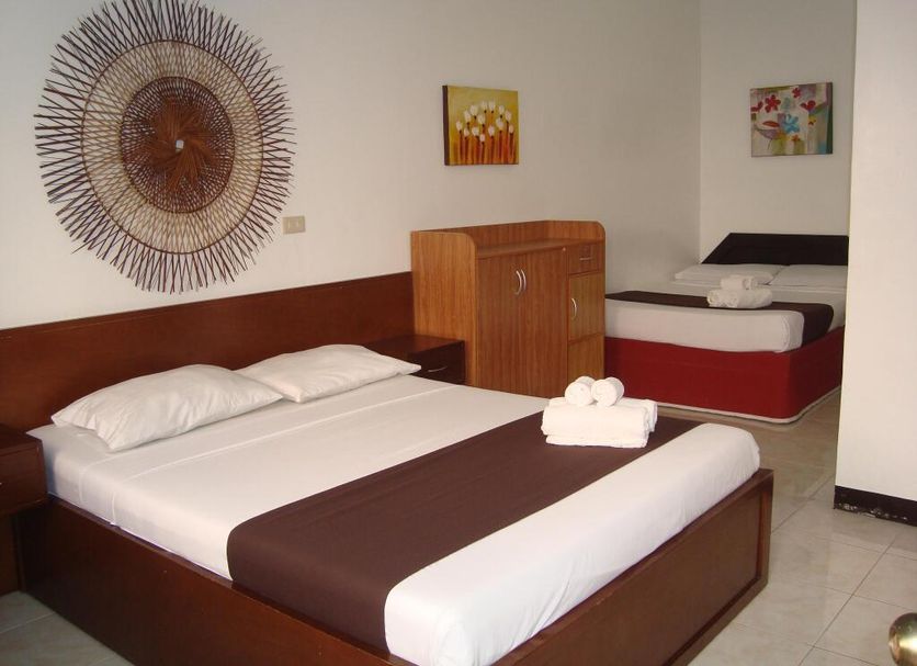 Azzurro Di Boracay Resort room with two beds, wall art, and tiled floor in Boracay.