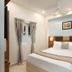 Grande Inn Tiruchirappalli guest room with double bed, bedside lights, and window curtains