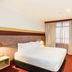 Statesman Hotel Canberra room with king bed, desk, wall-mounted TV and curtain-covered window