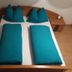 Gästehaus Klug in Sankt Stefan ob Stainz bed with teal bedding and pillows in a cozy guest room