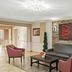 Red Roof Inn Etowah lobby with stone accent wall, black sofa, coffee table and seating chairs