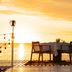 Sunset beachfront dining at Maradiva Villas Resort & Spa in Flic en Flac with table, chairs, and ocean view