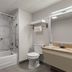 Baymont by Wyndham Branford/New Haven bathroom with tub-shower, toilet and granite vanity in Branford