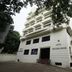 Hotel Goutham Manor in Chennai, exterior view of a white multi-story hotel building framed by trees