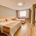Hotel Porto Salvador in Salvador: twin beds in a simple guest room with wood flooring and bathroom doorway