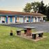 Best Motel Bowling Green exterior with motel rooms, lawn seating, and parking lot