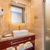 Beifang Langyue Hotel Beijing bathroom vanity with sink, mirror, and frosted glass shower door