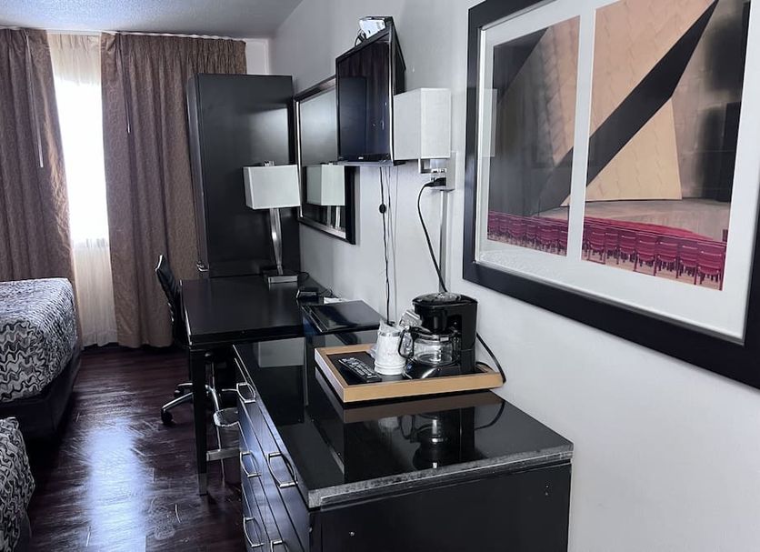 Amerivu Inn Park Falls room with two beds, desk, TV, and coffee maker beside a window with curtains