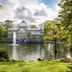 NH Madrid Nacional in Madrid, glass pavilion by a lake with fountain and lush park surroundings