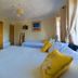 Aisleigh Guest House in Leitrim bedroom with two beds, wardrobe and window curtains