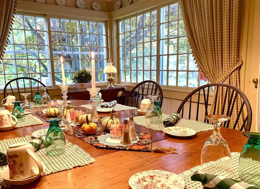 The Stockbridge Country Inn dining room with set table, large windows, and garden view in Stockbridge