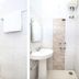 Goroomgo Mourya Inn Madhya Pradesh bathroom with toilet, pedestal sink, shower, and wall mirror in Harda