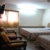 Skudai Baru Hotel in Skudai guest room with two beds and chairs by a curtained window